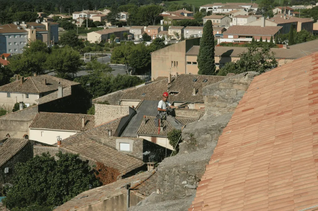 Cordiste progressant sur l’arête de la toiture de l’église