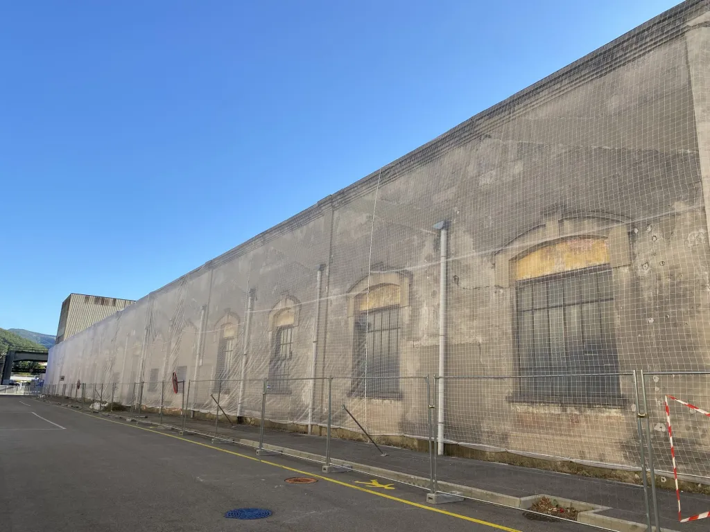 Façade sécurisée par filet, périmètre balisé au pied du bâtiment