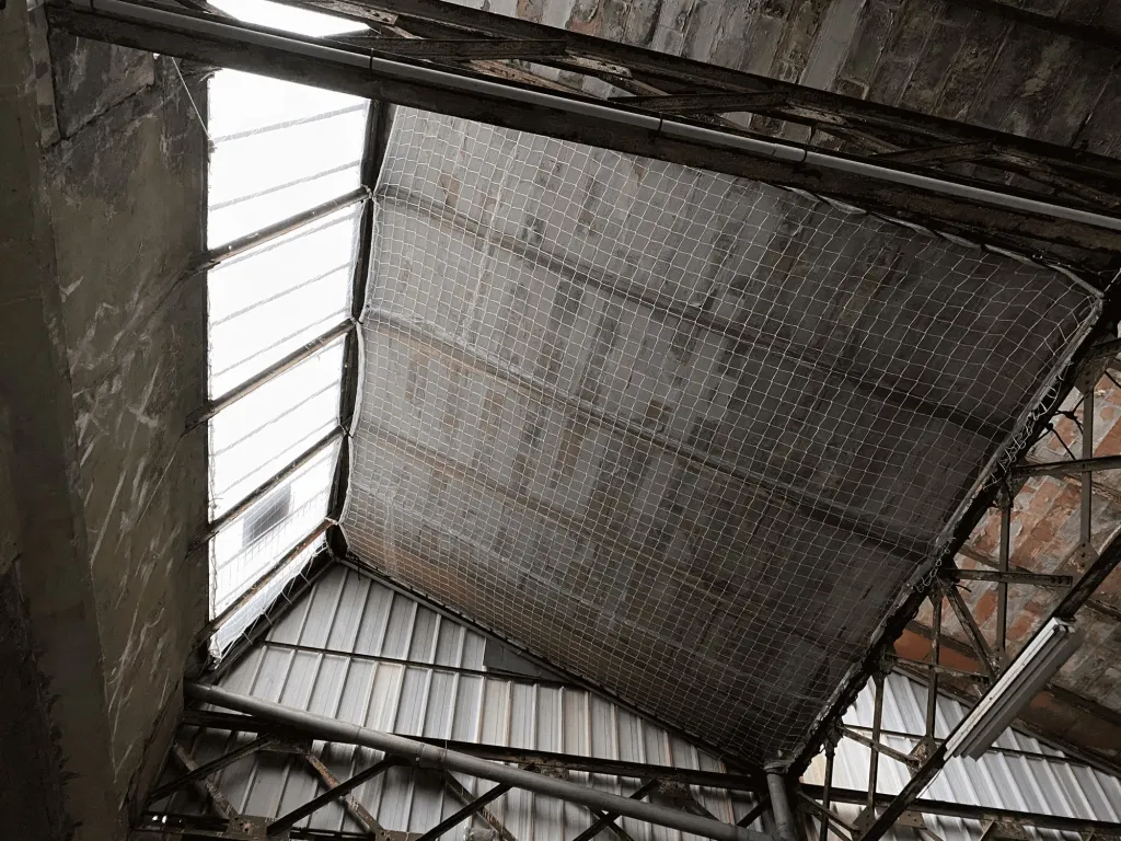 Filet de sécurité tendu sous la toiture du hangar