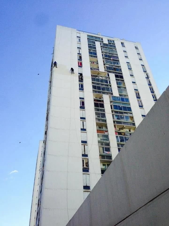 Trois cordistes traitant l’imperméabilisation d’une tour d’habitation